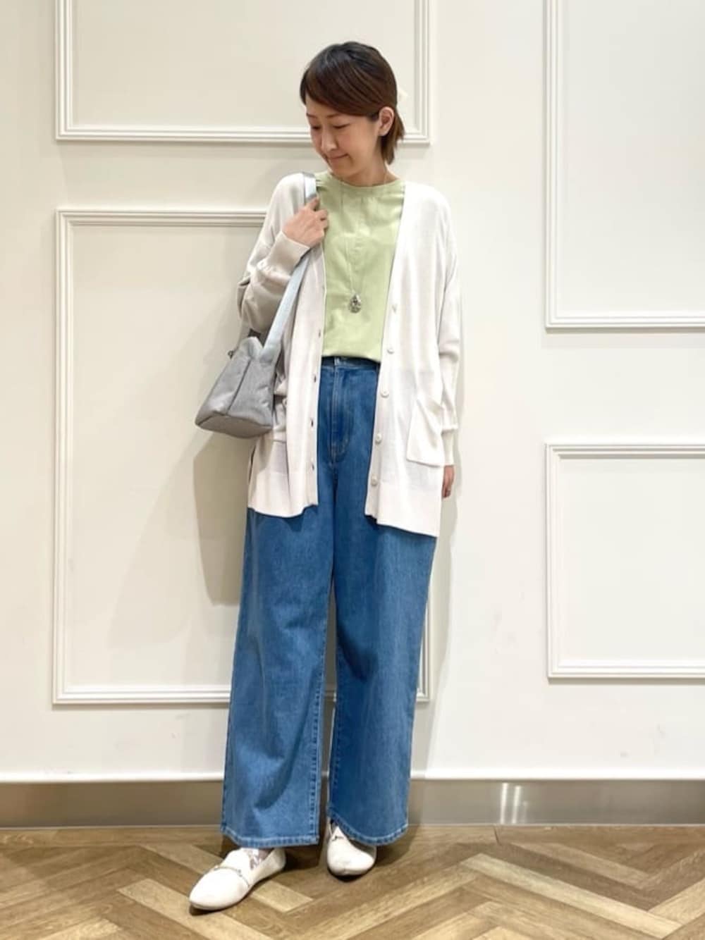 グレー系のカーディガン/ボレロ、グリーン系のシャツ/ブラウス、ブルー系のデニムパンツを着用したレディースの春コーディネートの1枚目の写真