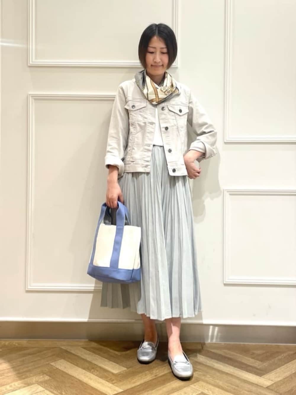 グレー系のデニムジャケット、ホワイト系のシャツ/ブラウス、グリーン系のスカートを着用したレディースの冬コーディネートの1枚目の写真