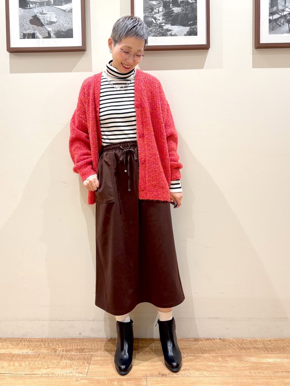 ホワイト系のニット/セーター、ピンク系のカーディガン/ボレロ、ブラウン系のスカートを着用したレディースの冬コーディネートの1枚目の写真