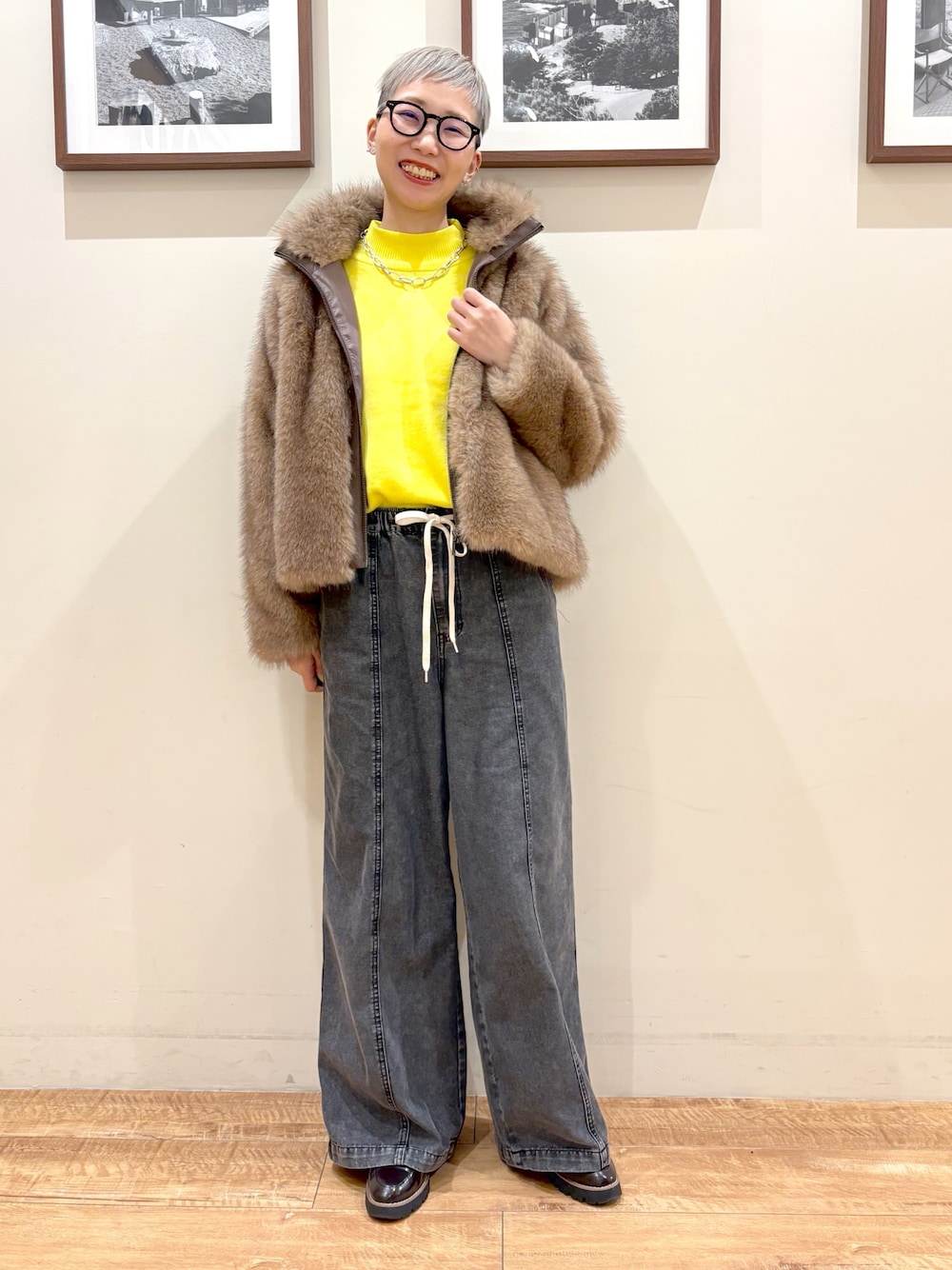 イエロー系のブルゾン、イエロー系のニット/セーター、ブラック系のデニムパンツを着用したレディースの冬コーディネートの1枚目の写真