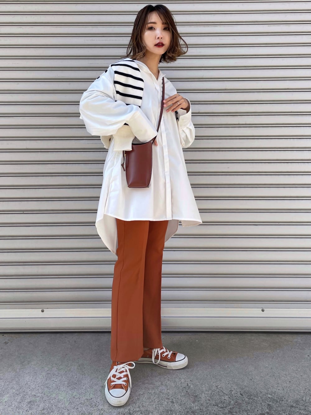 ホワイト系のシャツ/ブラウス、オレンジ系のスニーカーを着用したレディースの春コーディネートの1枚目の写真