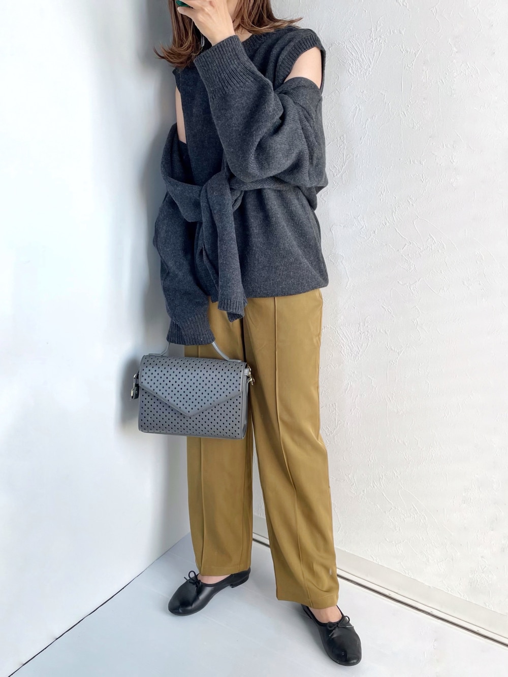 グレー系のニット/セーター、グレー系のバッグ、ブラック系のバレエシューズを着用したレディースの冬コーディネートの1枚目の写真