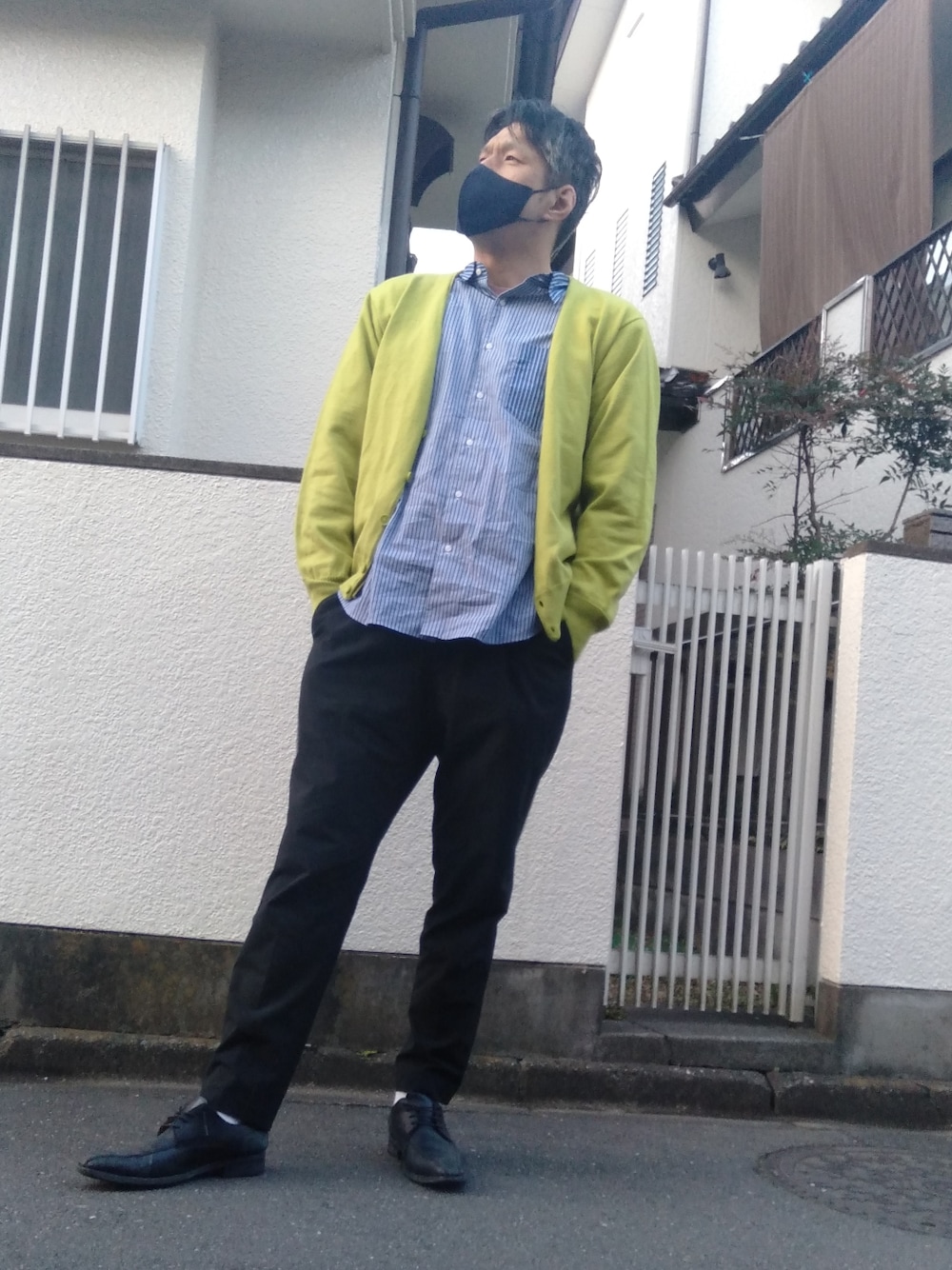 ブラック系のその他パンツ、ブラック系のドレスシューズ、グリーン系のカーディガン/ボレロを着用したメンズの春コーディネートの2枚目の写真