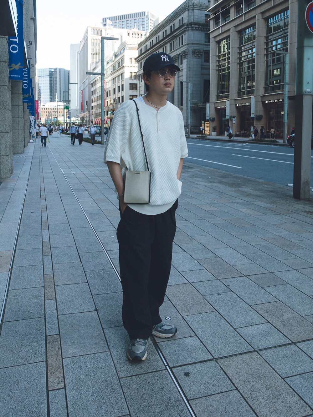グレー系のスニーカー、ホワイト系のショルダーバッグを着用したメンズの夏コーディネートの1枚目の写真