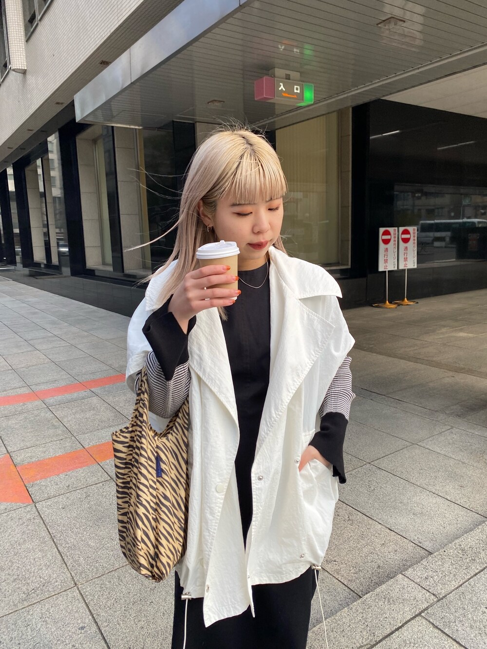 ホワイト系のブルゾン、グリーン系のニット/セーター、ブラック系のワンピースを着用したレディースの冬コーディネートの3枚目の写真