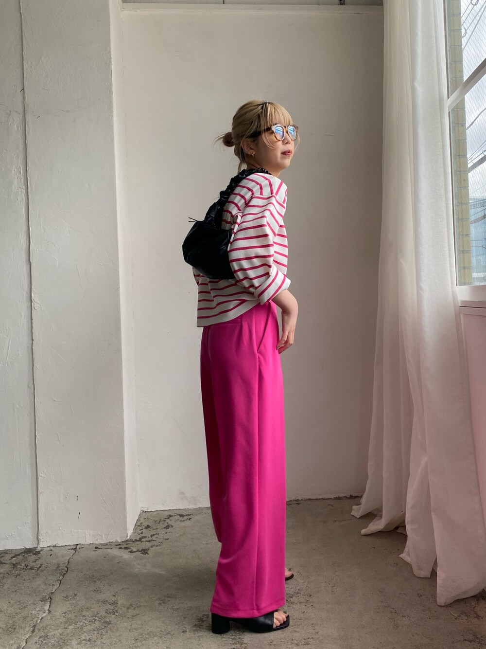 ピンク系のニット/セーター、ピンク系のスラックス、ブラック系のその他シューズを着用したレディースの冬コーディネートの2枚目の写真