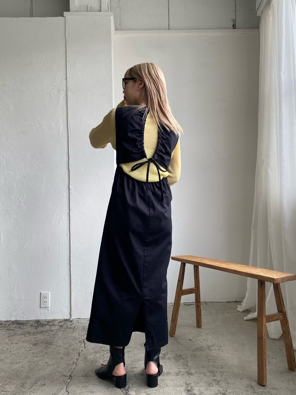 ブラック系のワンピース、イエロー系のニット/セーター、ブラック系のその他シューズを着用したレディースの冬コーディネートの5枚目の写真