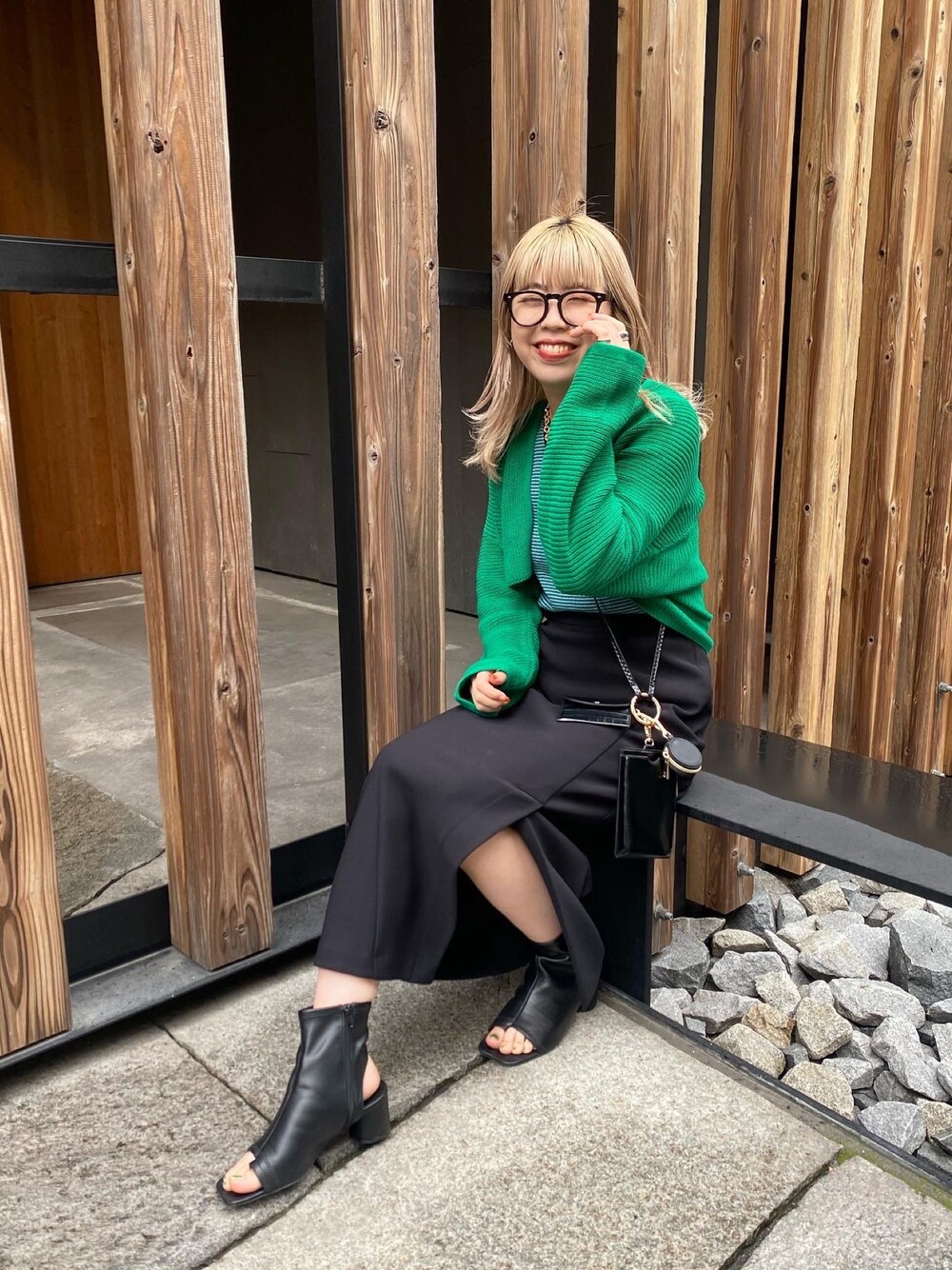 グリーン系のニット/セーター、グリーン系のニット/セーター、ブラック系のスカートを着用したレディースの冬コーディネートの2枚目の写真