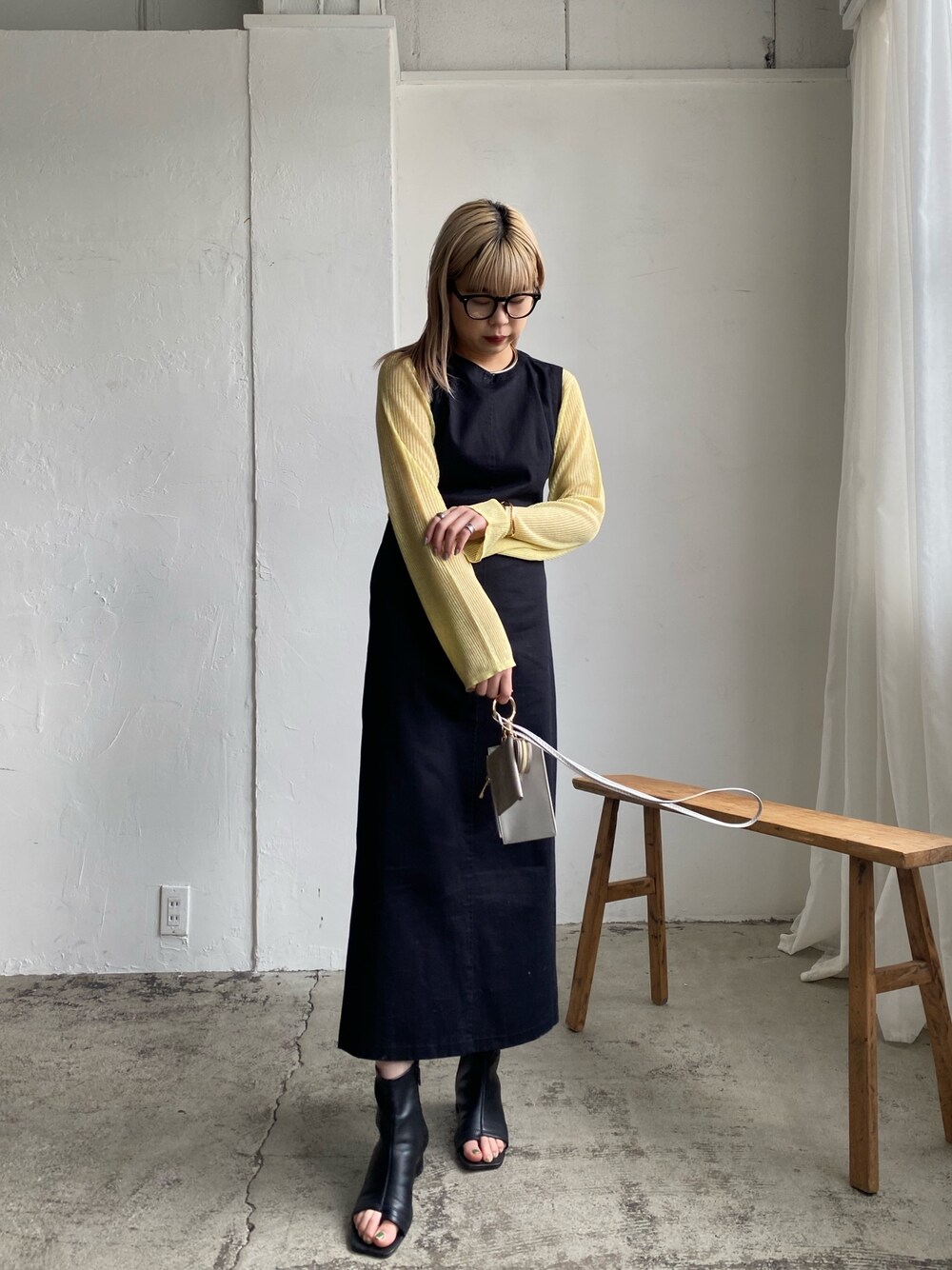 ブラック系のワンピース、イエロー系のニット/セーター、ブラック系のその他シューズを着用したレディースの冬コーディネートの2枚目の写真