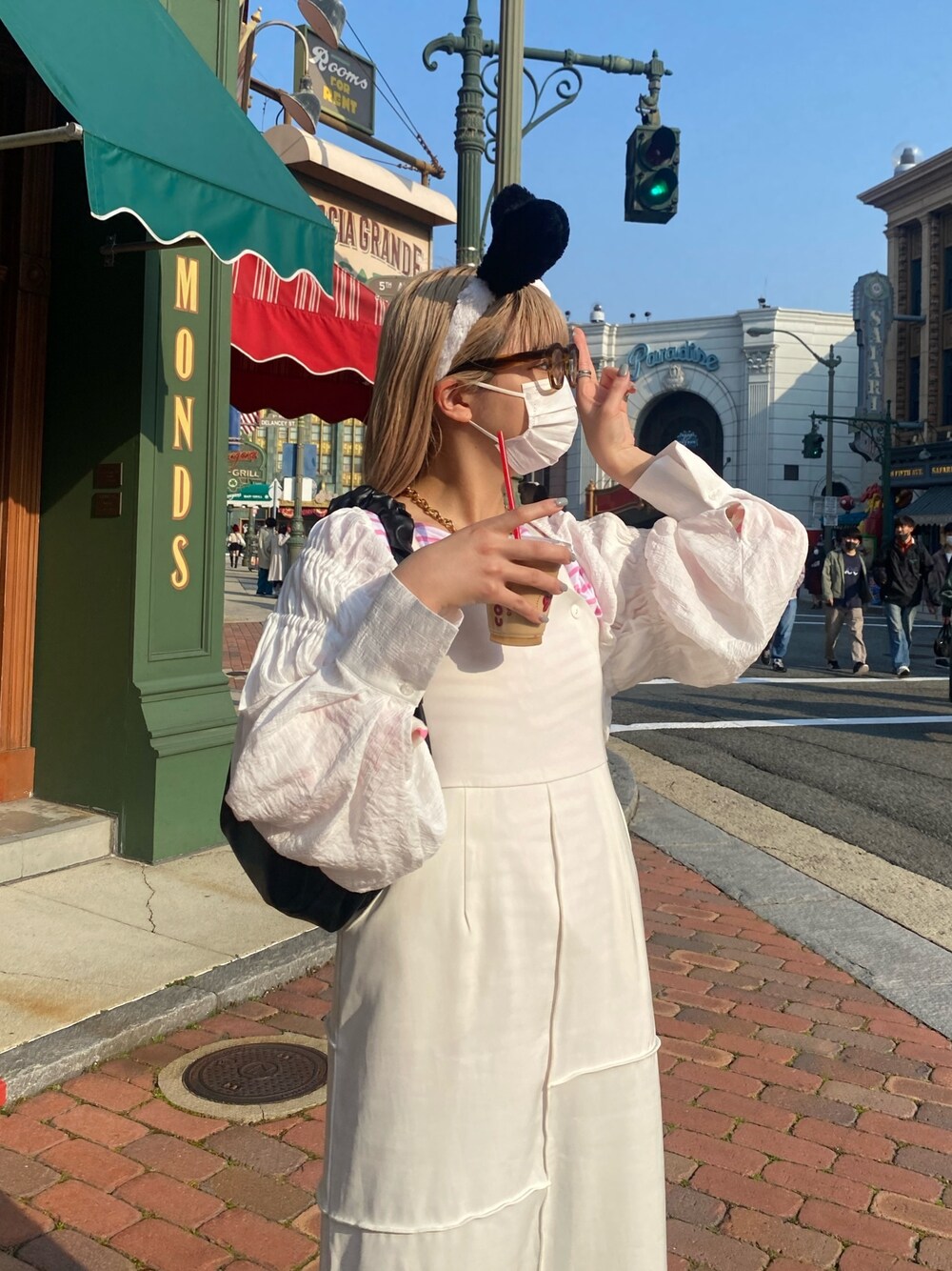 ピンク系のTシャツ/カットソー、ホワイト系のワンピース/ドレス、ブラック系のブーツを着用したレディースの春コーディネートの2枚目の写真