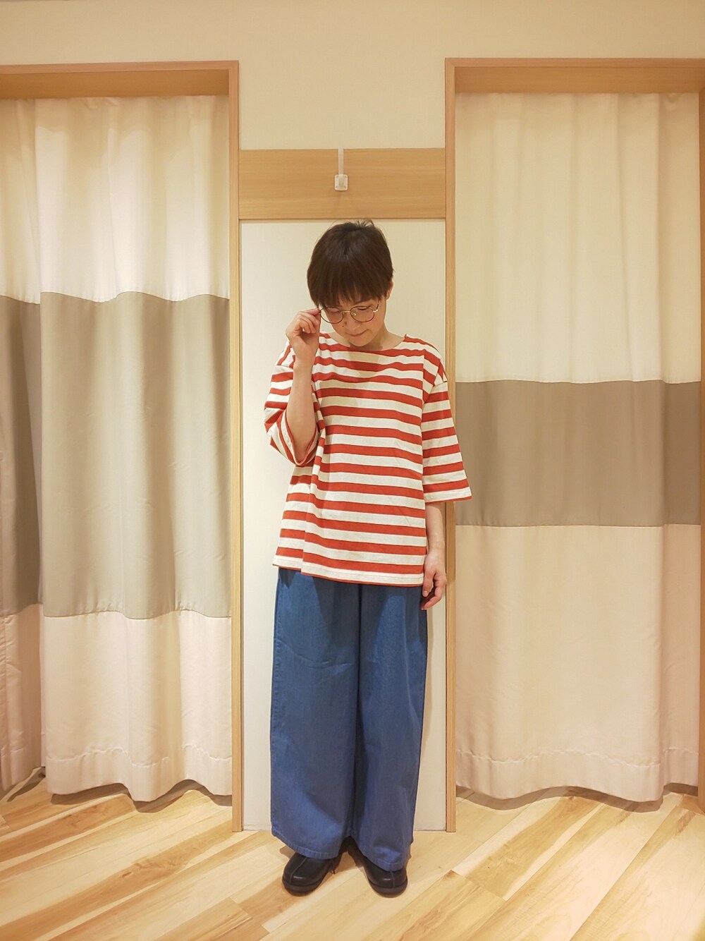 レッド系のTシャツ/カットソー、ブルー系のデニムパンツ、ブラック系のその他シューズを着用したレディースの春コーディネートの3枚目の写真