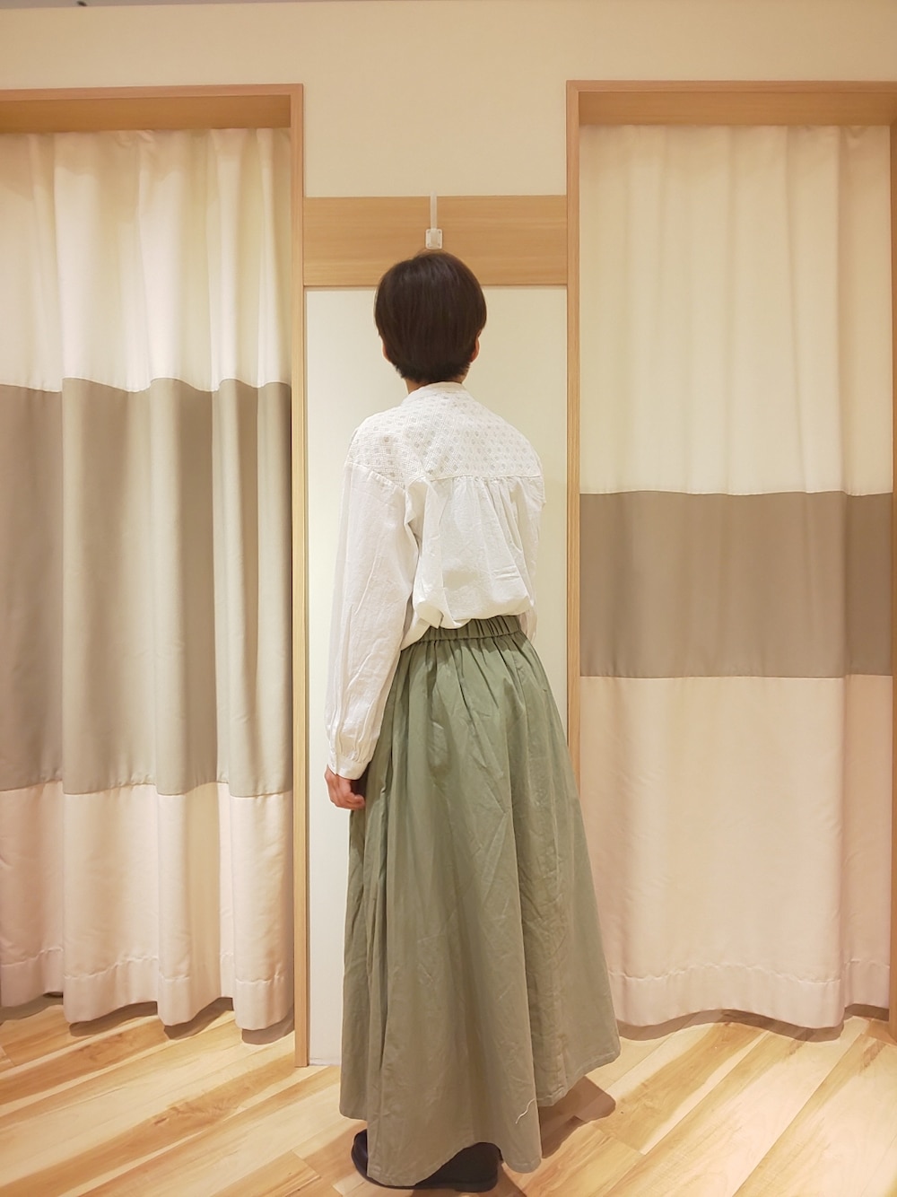 グリーン系のスカート、ホワイト系のシャツ/ブラウスを着用したレディースの春コーディネートの2枚目の写真