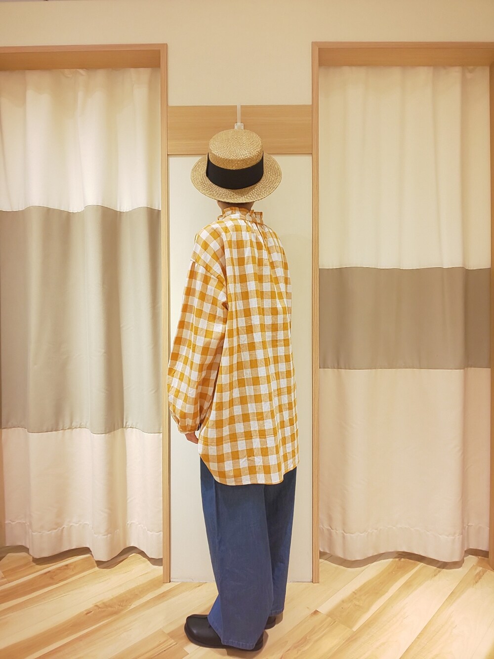 ブルー系のデニムパンツ、オレンジ系のシャツ/ブラウス、ブラック系のその他シューズを着用したレディースの春コーディネートの2枚目の写真