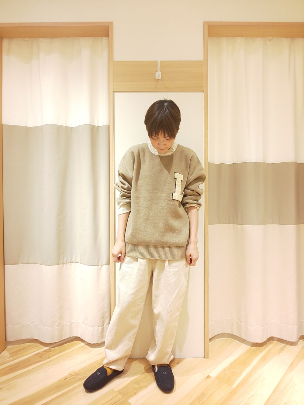 ベージュ系のニット/セーター、ホワイト系のその他パンツ、グレー系のその他シューズを着用したレディースの秋コーディネートの1枚目の写真