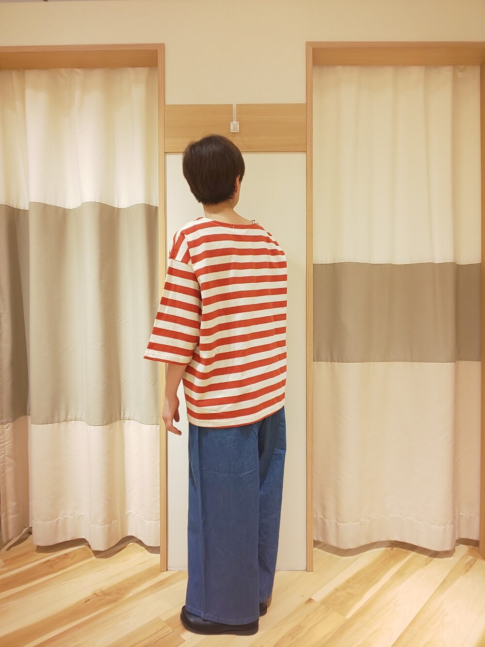 レッド系のTシャツ/カットソー、ブルー系のデニムパンツ、ブラック系のその他シューズを着用したレディースの春コーディネートの4枚目の写真