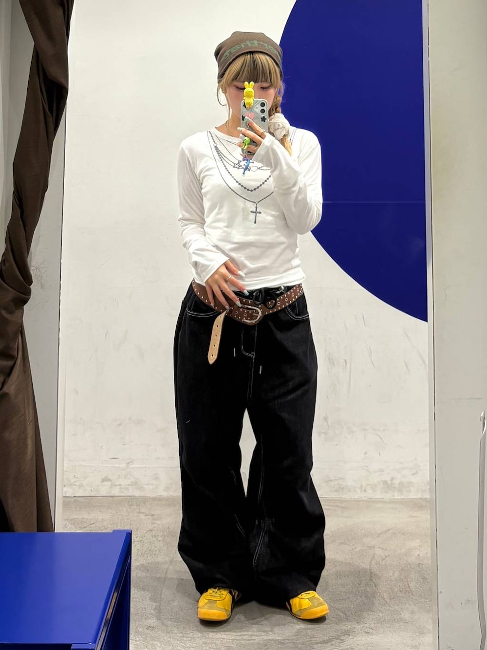 ブラック系のデニムパンツ、ホワイト系のTシャツ/カットソー、ブラウン系のベルトを着用したレディースの秋コーディネートの1枚目の写真