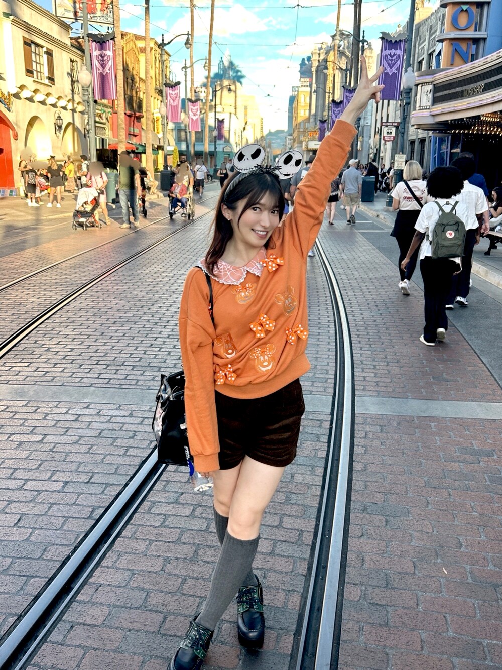 ブラウン系のその他パンツ、オレンジ系のトップス、ブラック系のバッグを着用したレディースの秋コーディネートの1枚目の写真