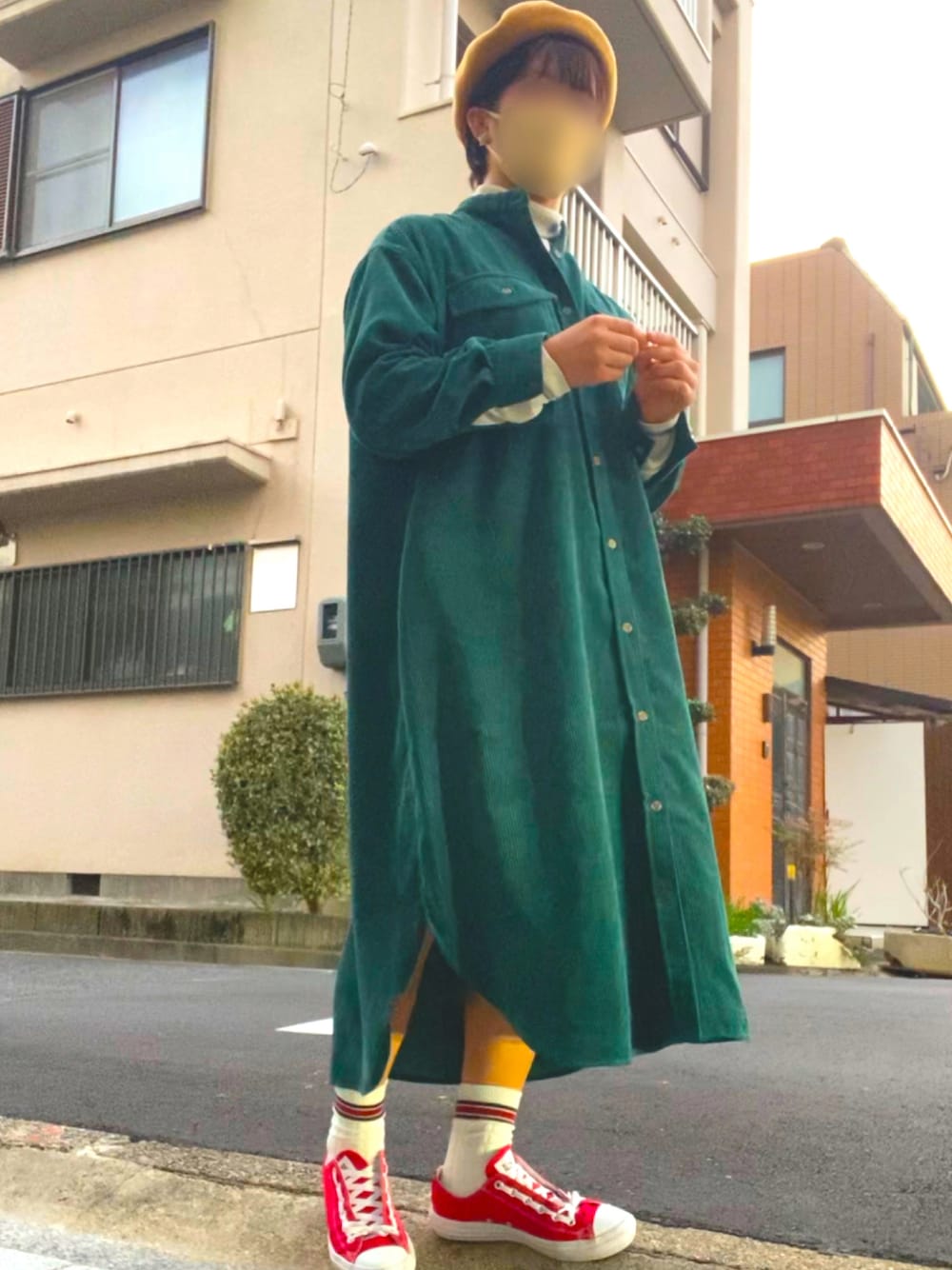 レッド系のスニーカー、グリーン系のワンピース、ホワイト系のトップスを着用したレディースの秋コーディネートの1枚目の写真