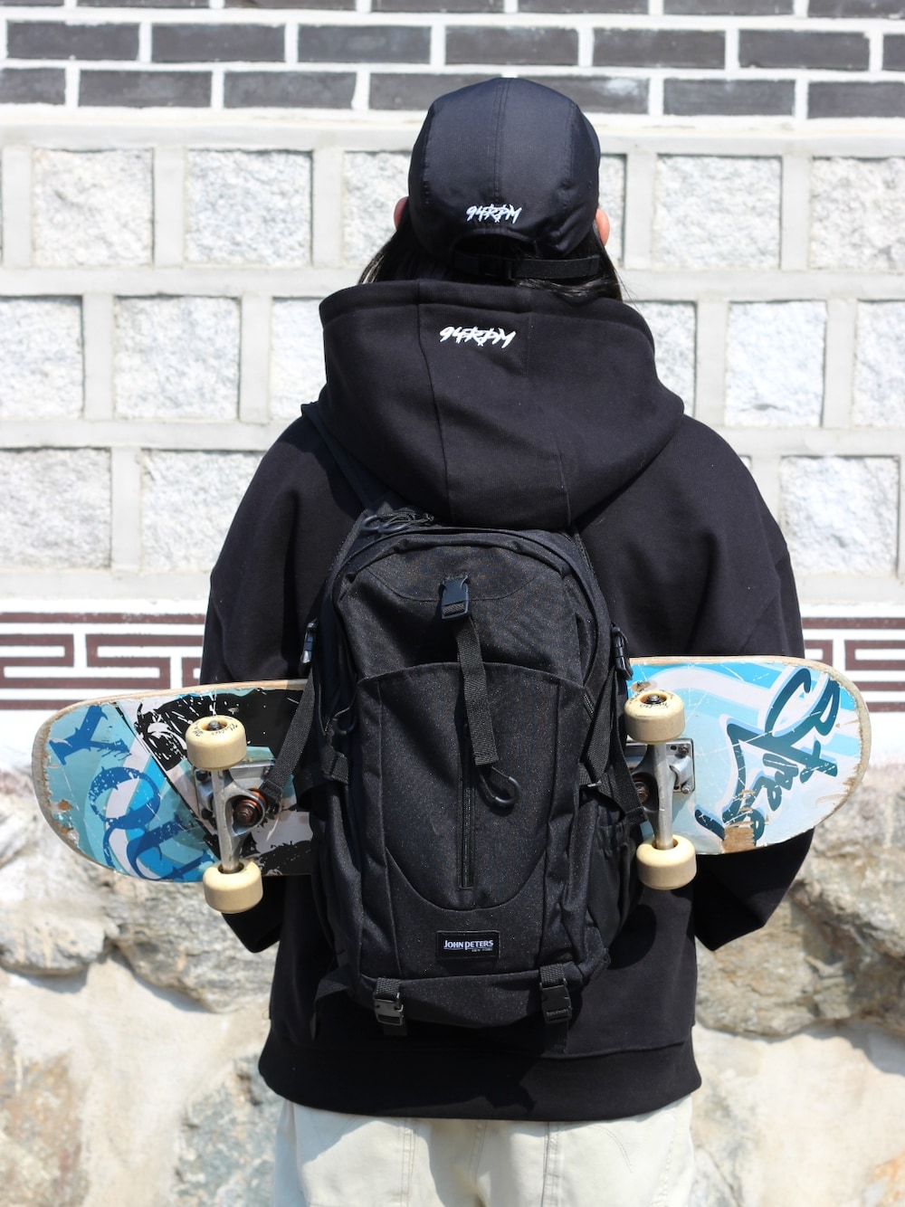 ブラック系のパーカー、ベージュ系のデニムパンツを着用したメンズの春コーディネートの5枚目の写真