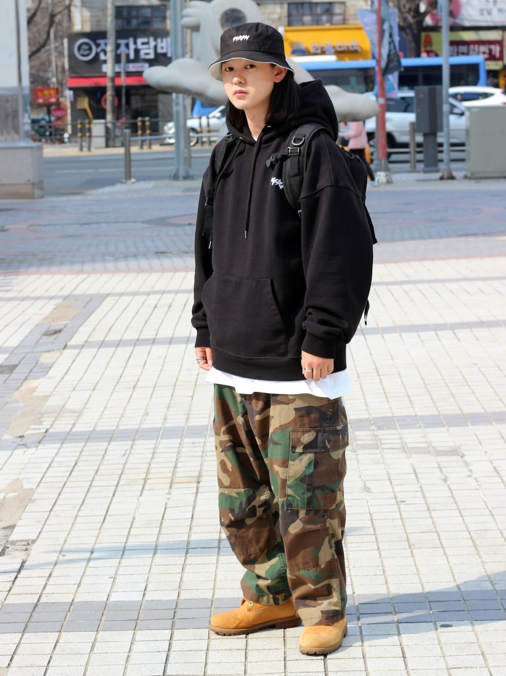 オレンジ系のブーツを着用したメンズの春コーディネートの2枚目の写真