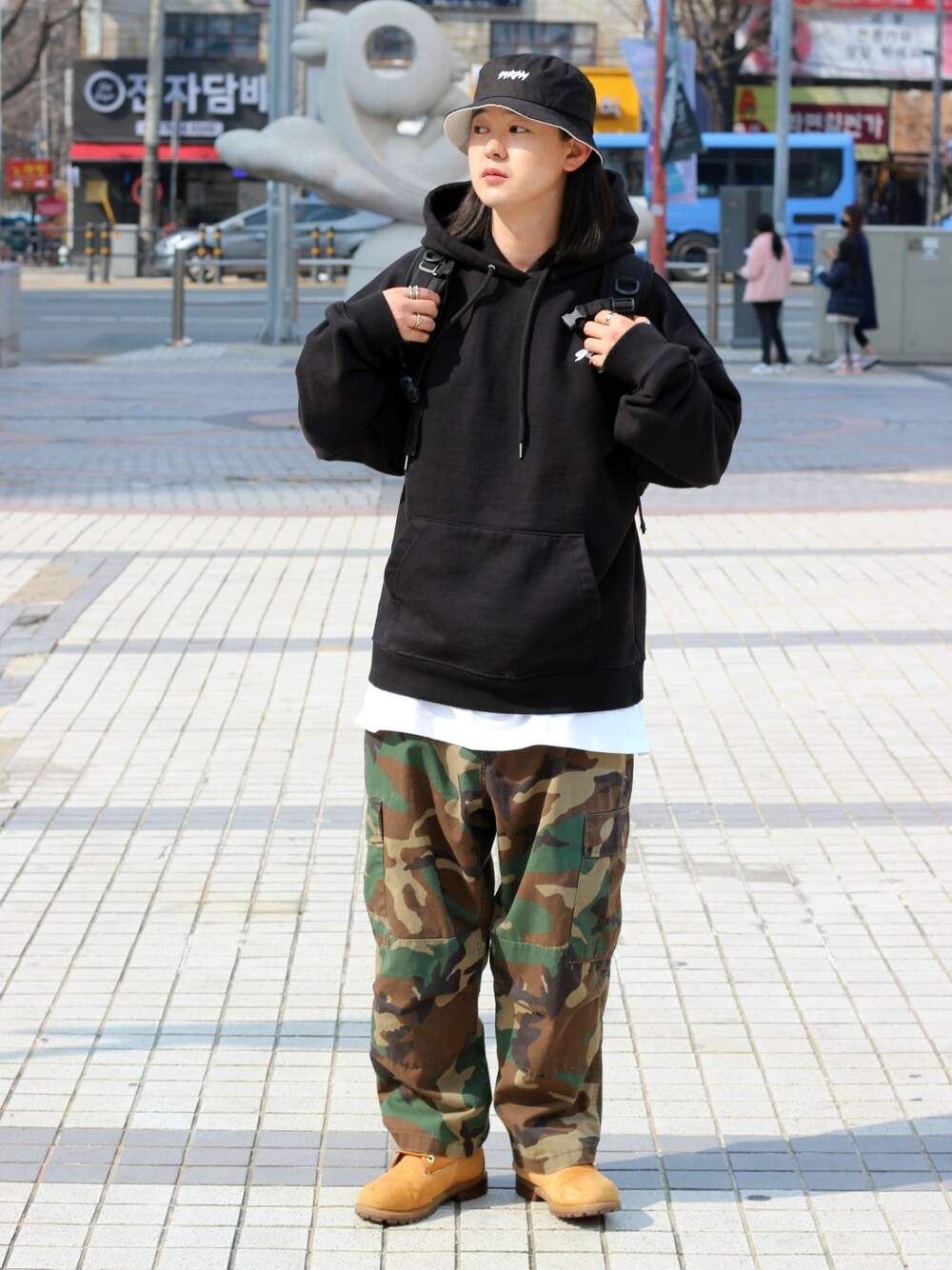 オレンジ系のブーツを着用したメンズの春コーディネートの3枚目の写真