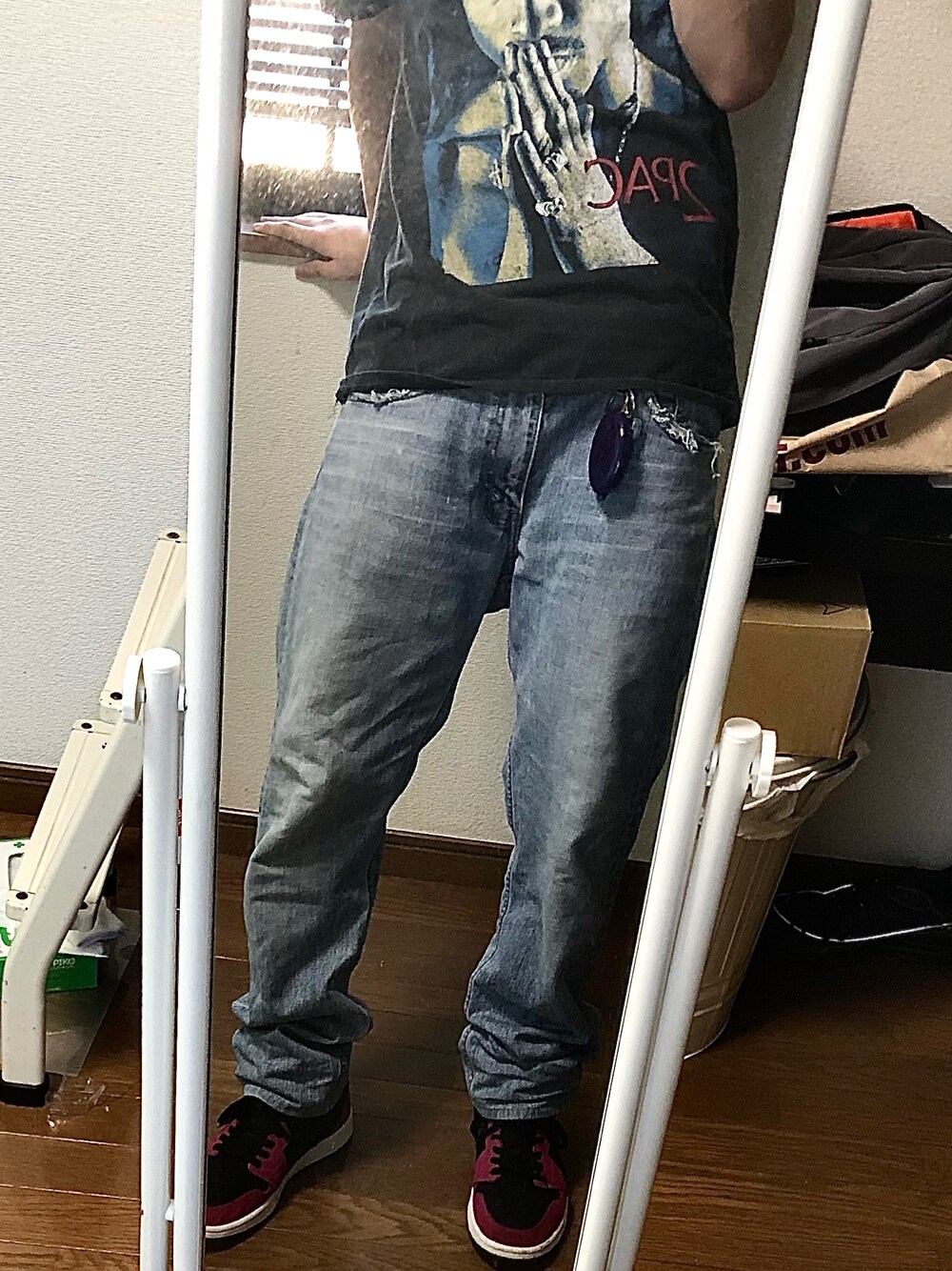 ブルー系のデニムパンツ、ピンク系のスニーカーを着用したメンズの夏コーディネートの1枚目の写真