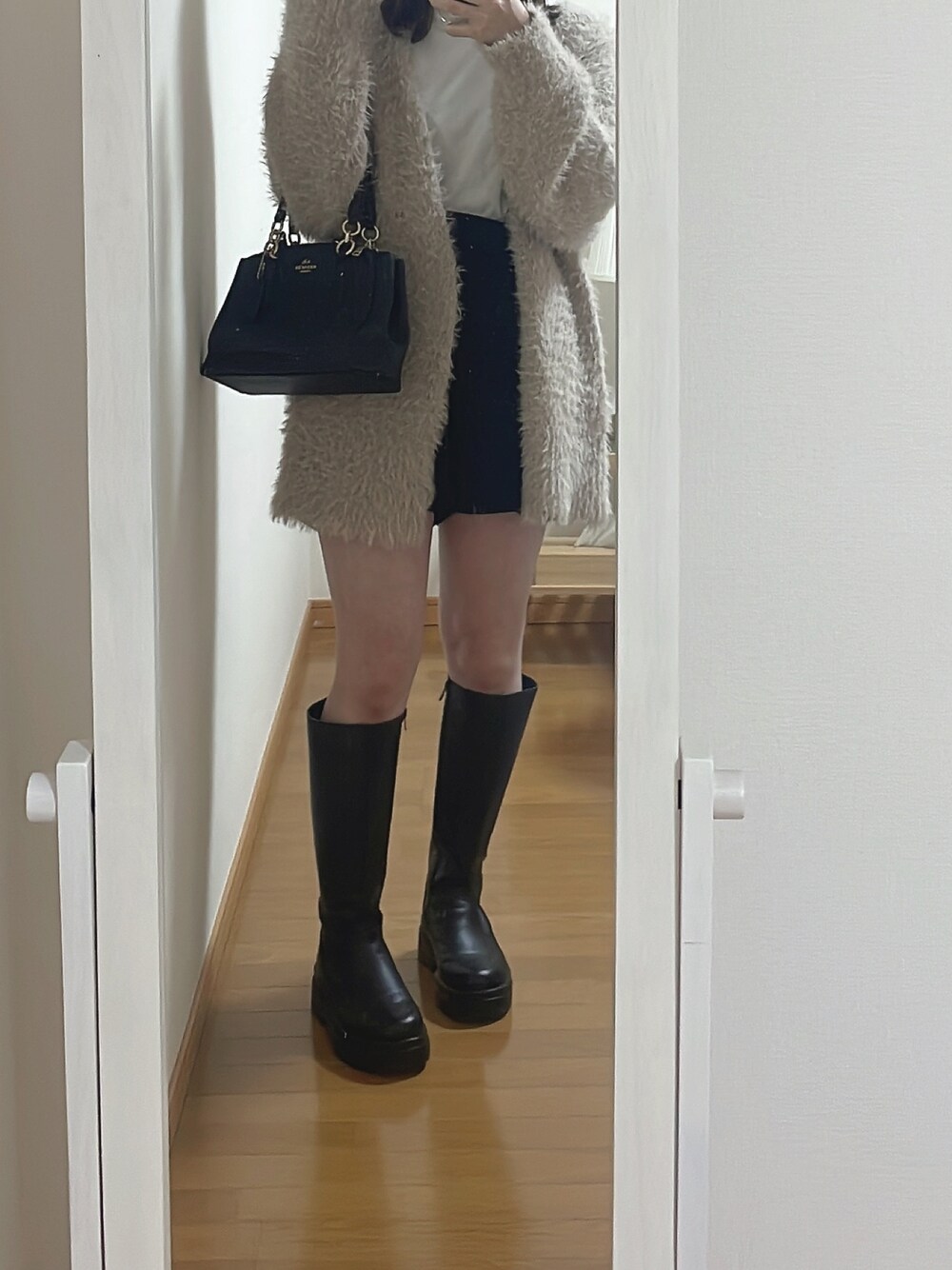 ブラック系のショルダーバッグ、ブラック系のその他パンツ、ブラック系のブーツを着用したレディースの秋コーディネートの1枚目の写真