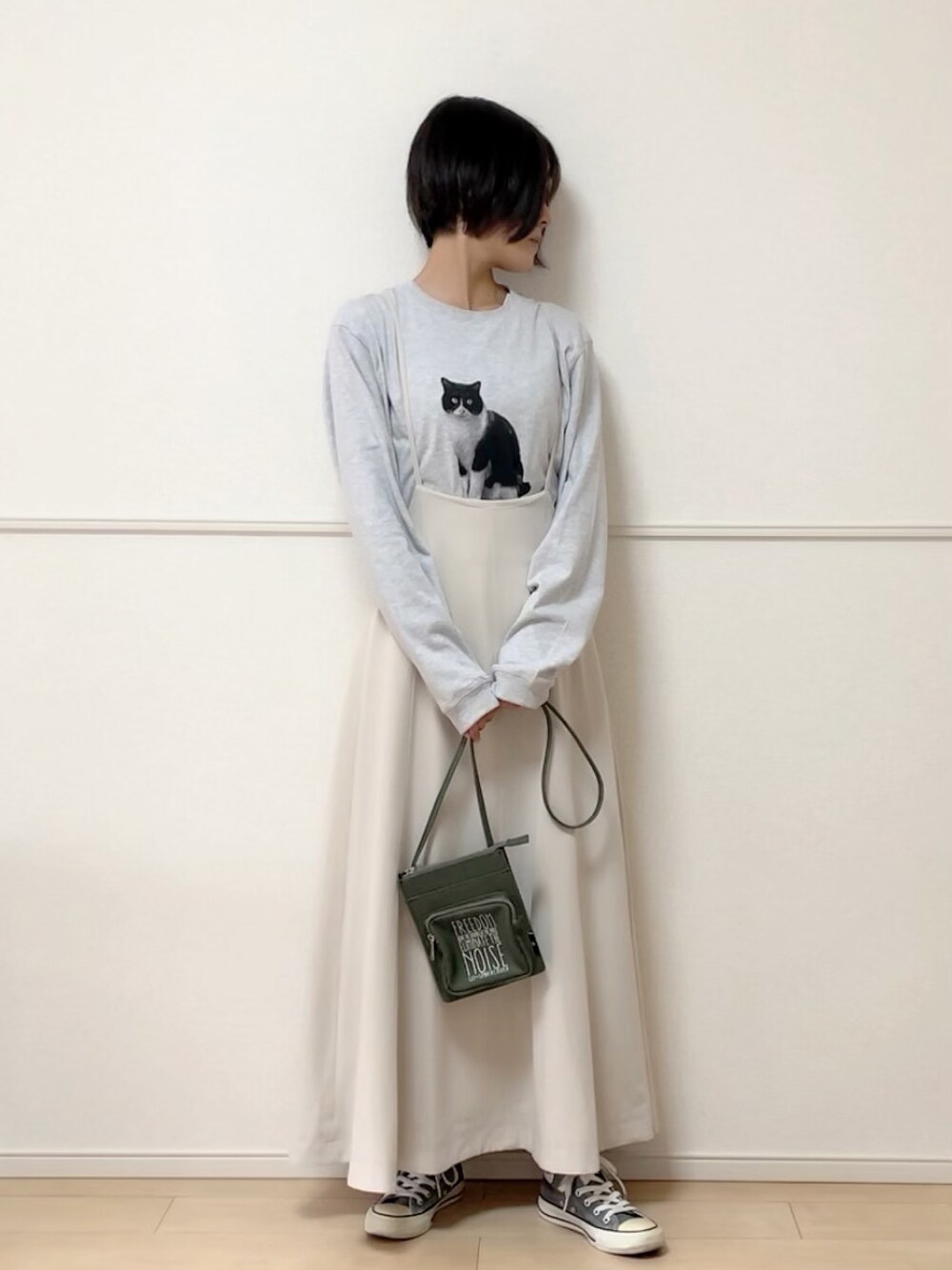 グレー系のTシャツ/カットソー、ホワイト系のスカート、グレー系のスニーカーを着用したレディースの秋コーディネートの1枚目の写真