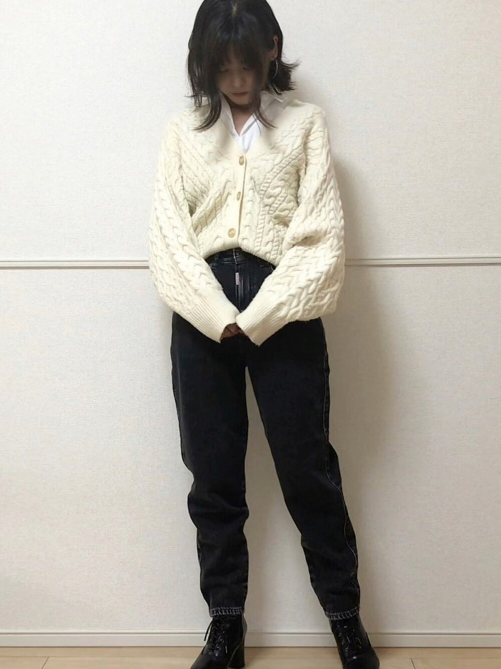 ブラック系のデニムパンツ、ホワイト系のカーディガン/ボレロ、ホワイト系のニット/セーターを着用したレディースの秋コーディネートの1枚目の写真