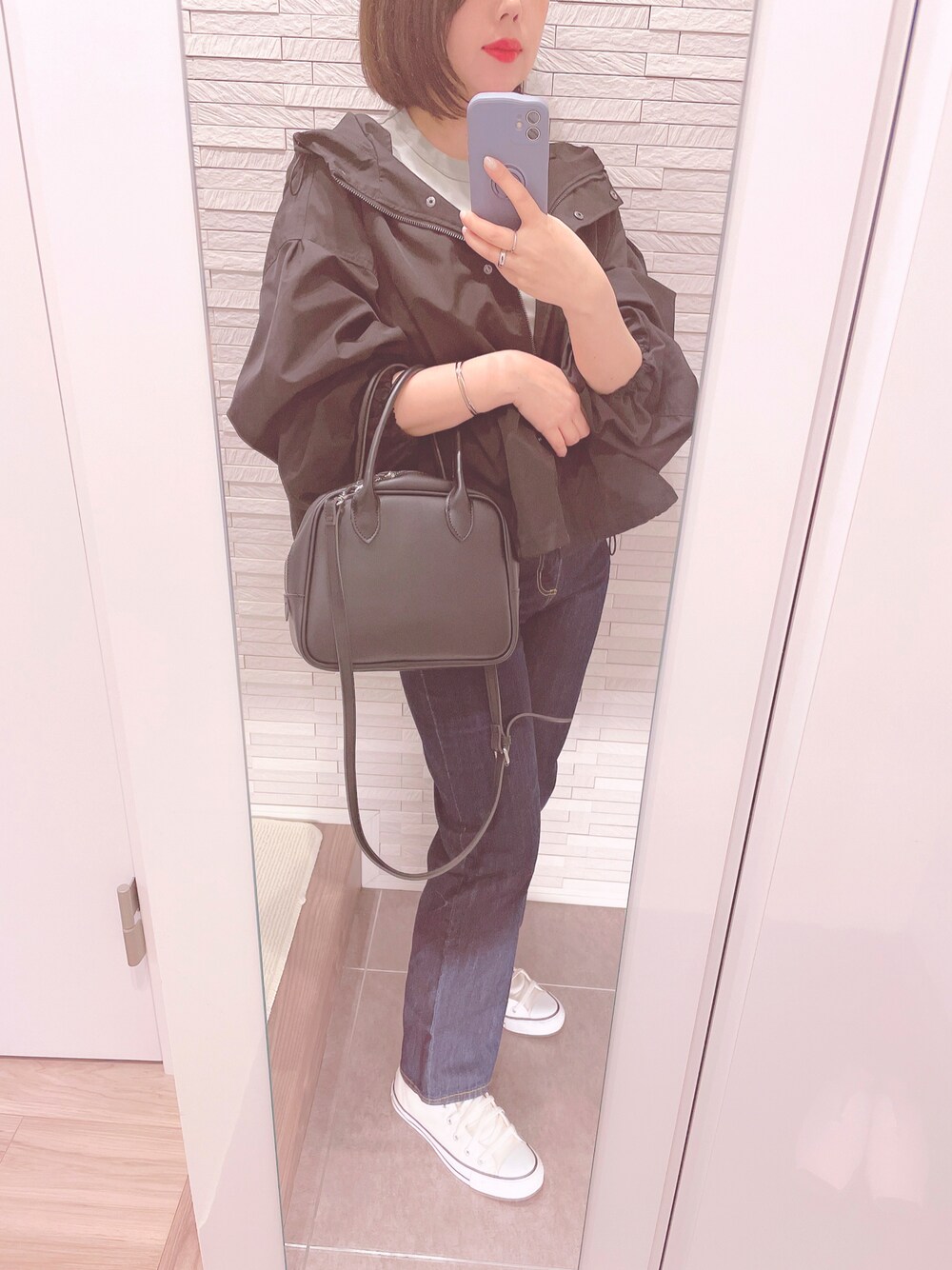 グリーン系のTシャツ/カットソー、ブラック系のボストンバッグ、ブルー系のデニムパンツを着用したレディースの春コーディネートの1枚目の写真