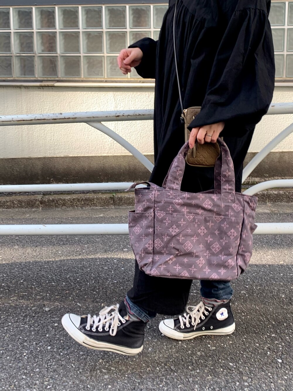 グレー系のトートバッグ、ブラック系のワンピース、グレー系のTシャツ/カットソーを着用したレディースの冬コーディネートの2枚目の写真