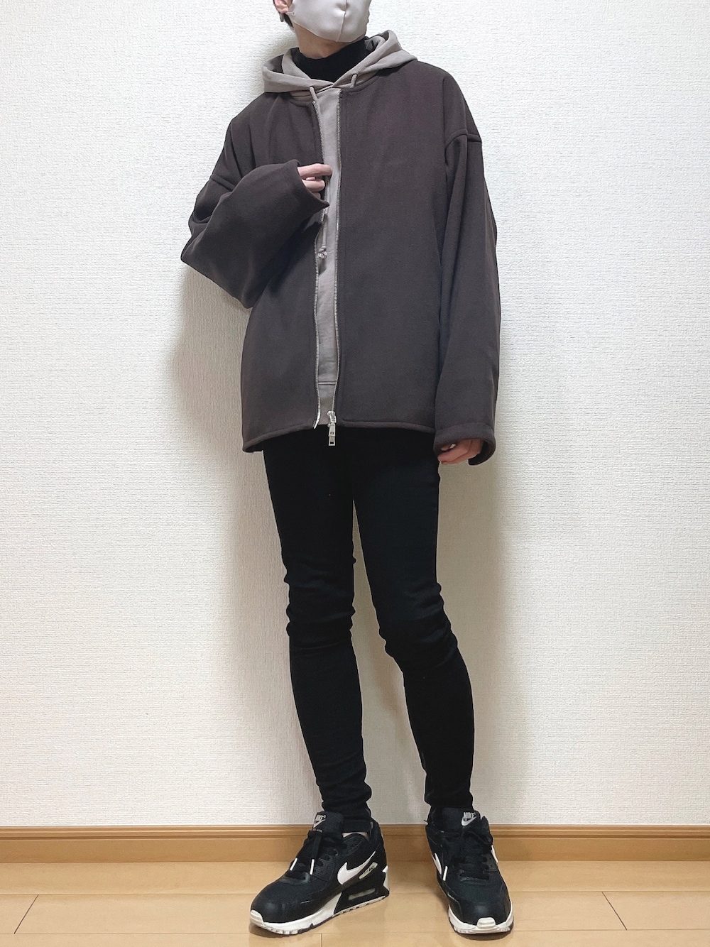レッド系のブルゾン、ブラウン系のパーカー、ブラック系のTシャツ/カットソーを着用したメンズの冬コーディネートの1枚目の写真