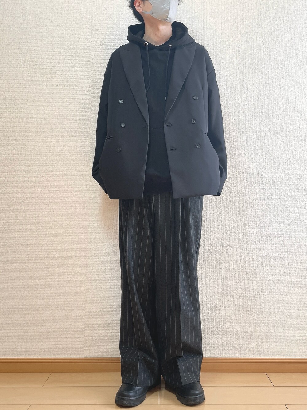 ブラック系のテーラードジャケット、ブラック系のパーカー、ブラック系のパンツを着用したメンズの冬コーディネートの1枚目の写真