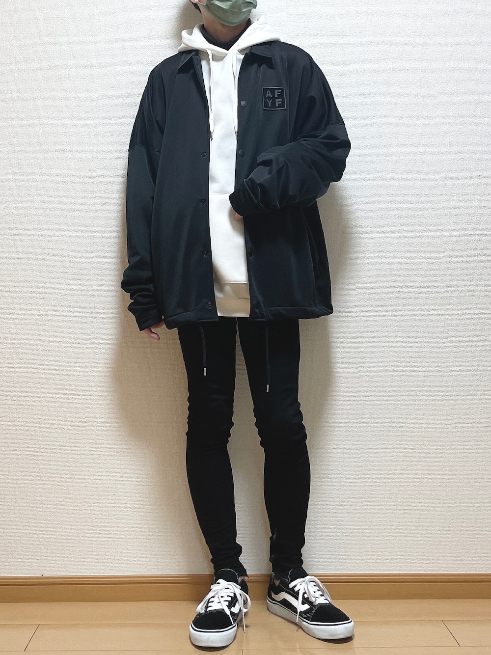 ブラック系のブルゾン、ホワイト系のパーカー、ブラウン系のTシャツ/カットソーを着用したメンズの冬コーディネートの1枚目の写真