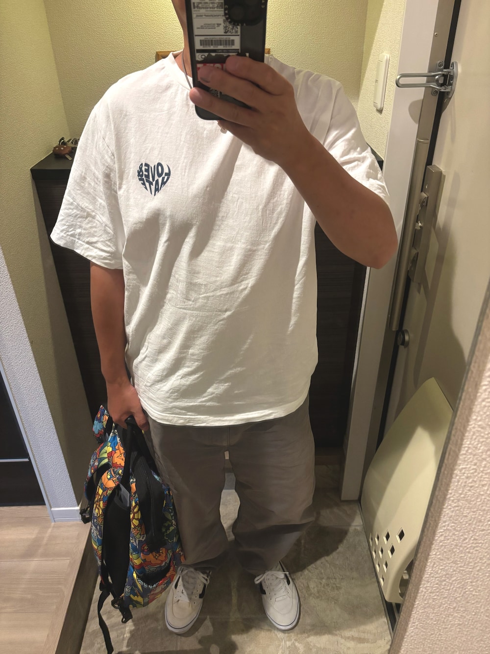ホワイト系のTシャツ/カットソー、グレー系のチノパンツ、ホワイト系のスニーカーを着用したメンズの秋コーディネートの1枚目の写真