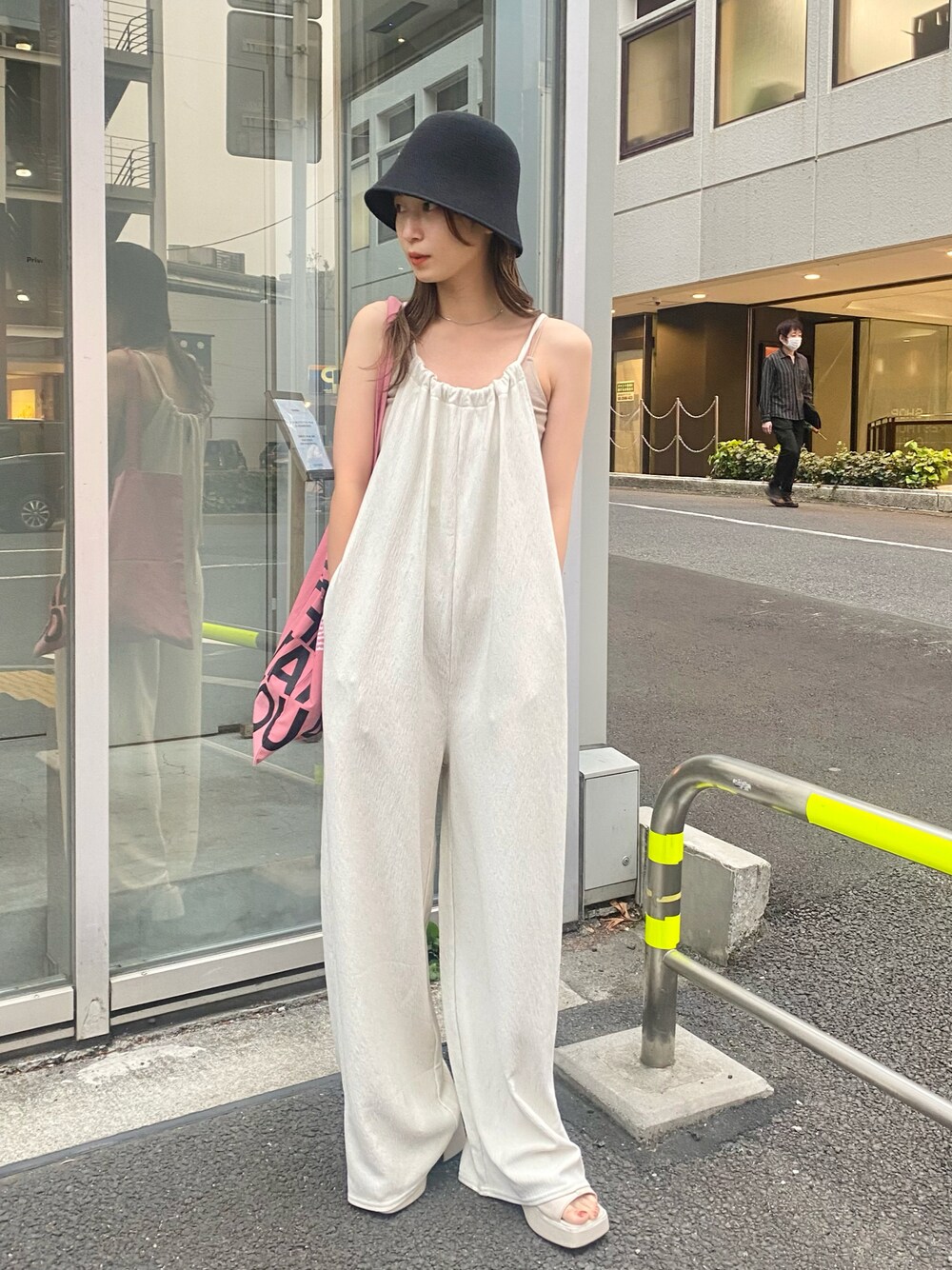 ホワイト系のキャミソール、ホワイト系のサロペット/オーバーオール、ピンク系のトートバッグを着用したレディースの春コーディネートの1枚目の写真