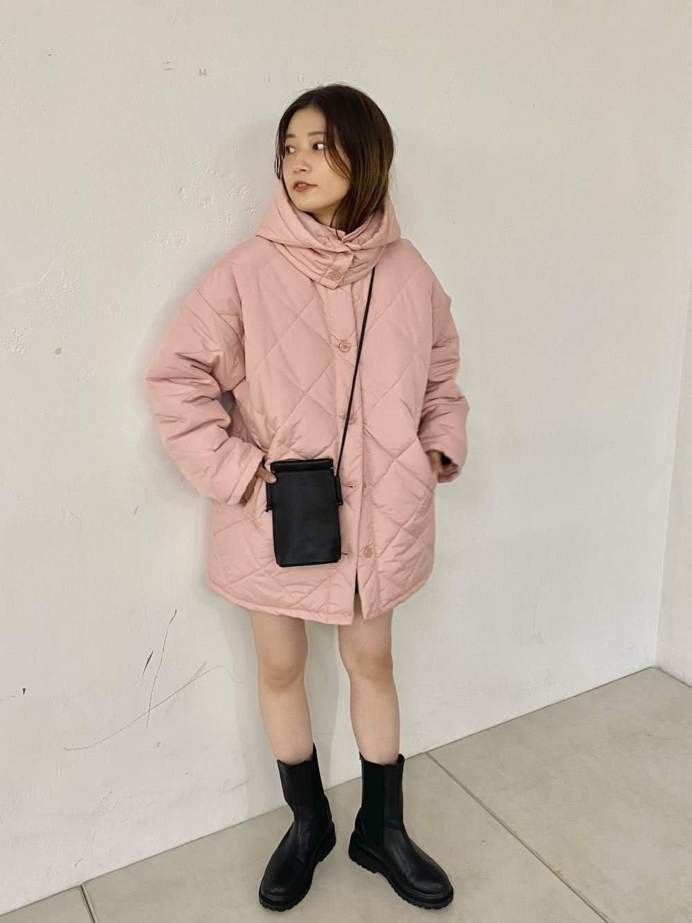 ブラック系のブーツ、ピンク系のダウンジャケット/コートを着用したレディースの秋コーディネートの1枚目の写真
