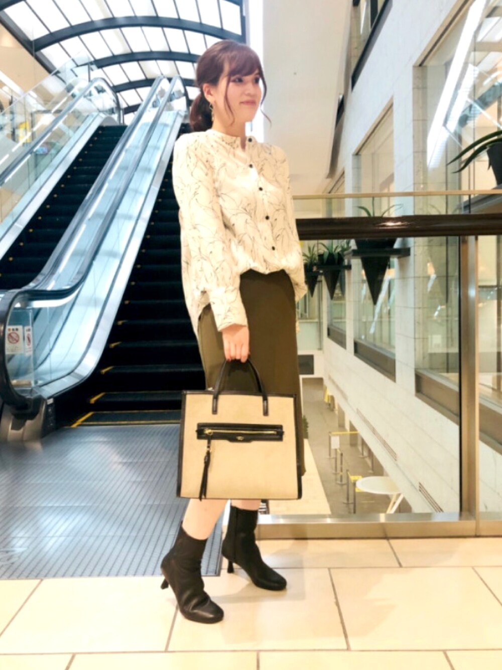 ベージュ系のトートバッグ、ブラック系のブーツを着用したレディースの冬コーディネートの1枚目の写真