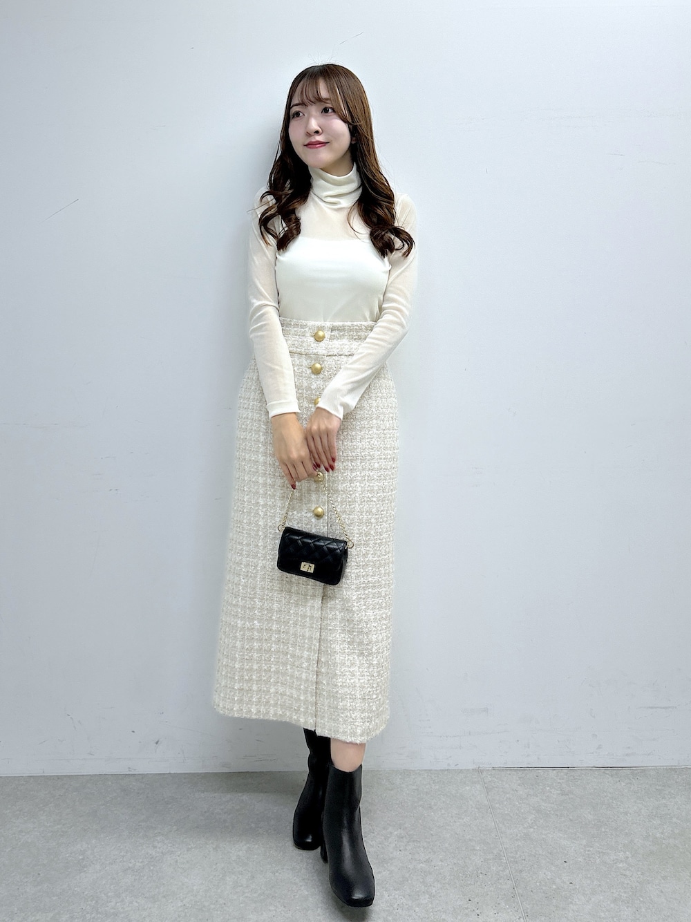 ホワイト系のTシャツ/カットソー、ベージュ系のスカート、ブラック系のブーツを着用したレディースの秋コーディネートの1枚目の写真