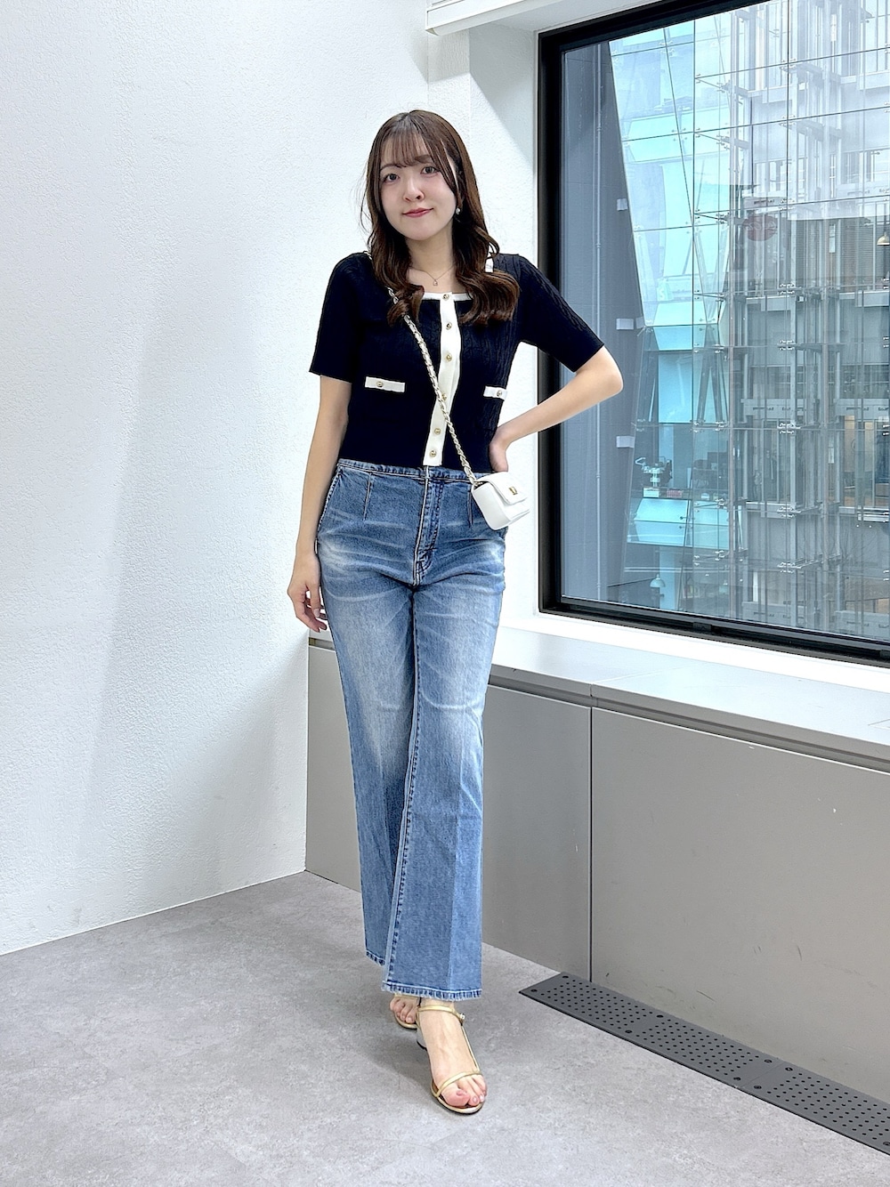 ブルー系のニット/セーター、ブルー系のデニムパンツを着用したレディースの春コーディネートの1枚目の写真