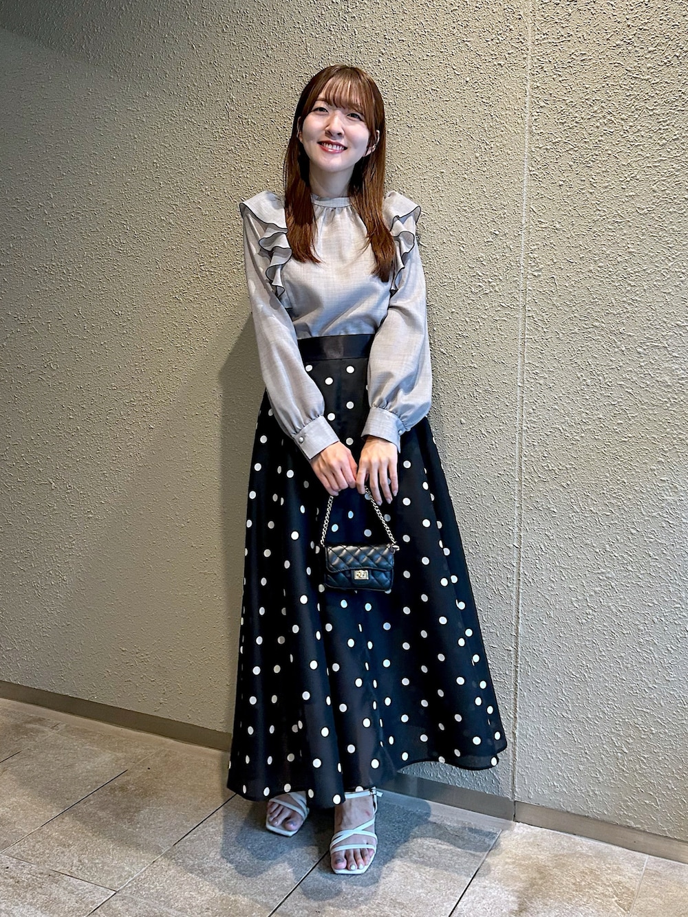 グレー系のシャツ/ブラウス、ブラック系のスカートを着用したレディースの秋コーディネートの1枚目の写真