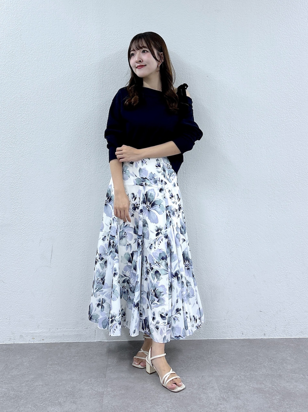 ブルー系のTシャツ/カットソー、ホワイト系のスカートを着用したレディースの夏コーディネートの1枚目の写真