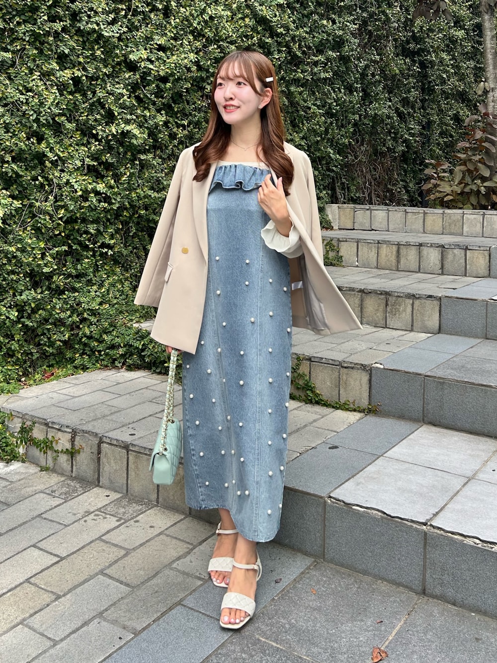 ブルー系のワンピース、ベージュ系のテーラードジャケットを着用したレディースの秋コーディネートの1枚目の写真