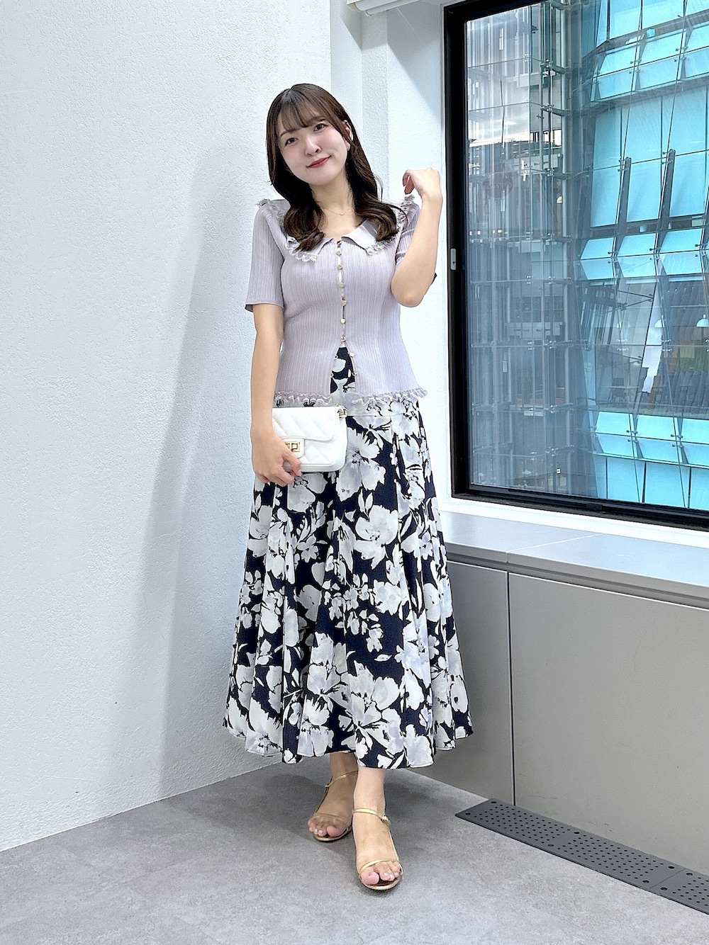 パープル系のニット/セーター、ブルー系のスカートを着用したレディースの夏コーディネートの1枚目の写真