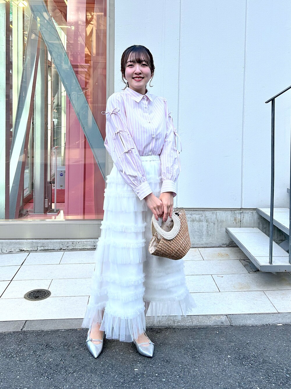 ピンク系のシャツ/ブラウス、ホワイト系のスカート、ベージュ系のかごバッグを着用したレディースの冬コーディネートの1枚目の写真