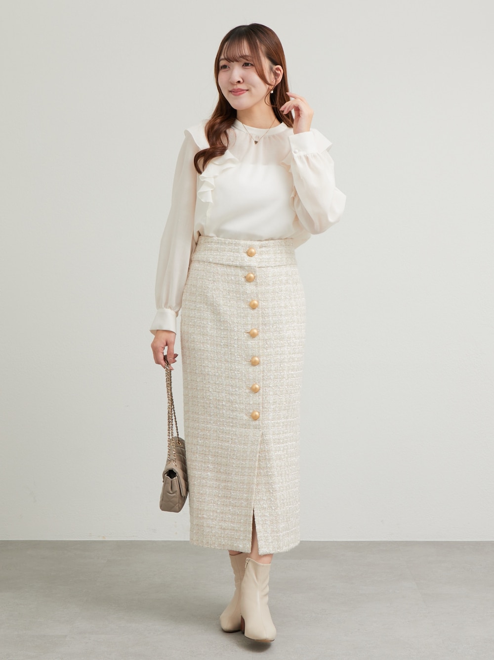 ホワイト系のシャツ/ブラウス、ベージュ系のスカートを着用したレディースの秋コーディネートの1枚目の写真