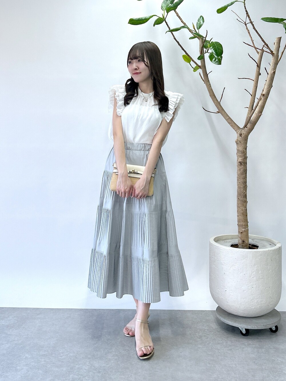 ホワイト系のシャツ/ブラウス、グレー系のスカートを着用したレディースの春コーディネートの1枚目の写真