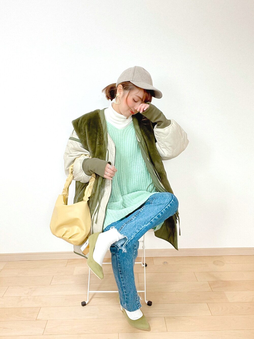 グリーン系のニット/セーター、グリーン系のミリタリージャケット、ホワイト系のTシャツ/カットソーを着用したレディースの冬コーディネートの1枚目の写真