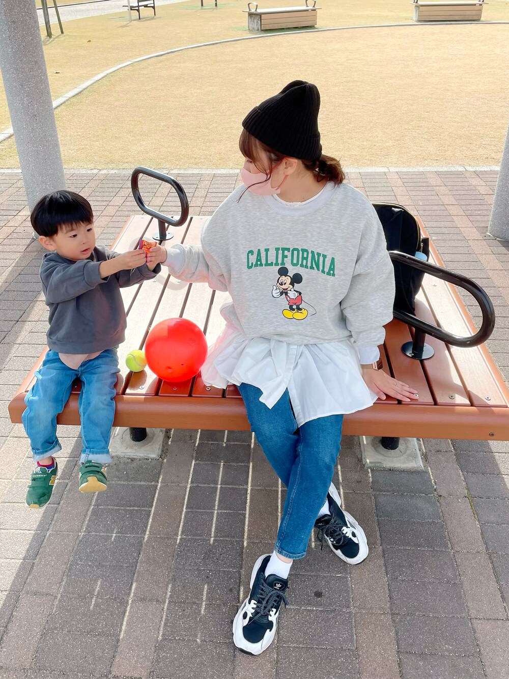 グレー系のスウェット、ホワイト系のシャツ/ブラウス、ブルー系のデニムパンツを着用したレディースの秋コーディネートの1枚目の写真