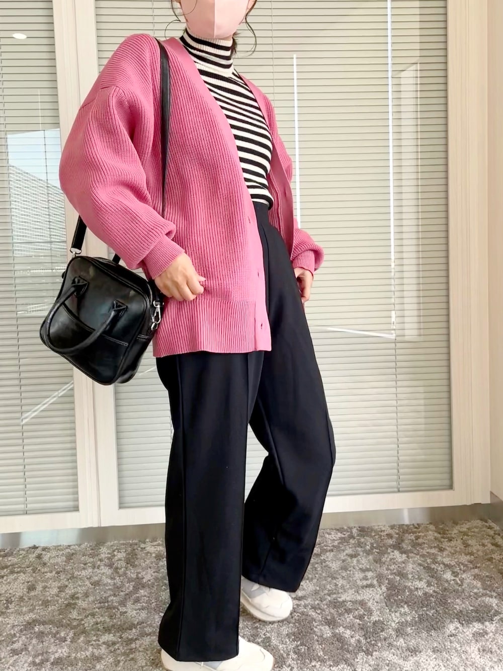 ピンク系のカーディガン/ボレロ、ブラック系のニット/セーター、ブラック系のパンツを着用したレディースの秋コーディネートの1枚目の写真